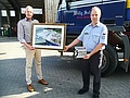 Jörg Mummert (Geschäftsführer der Willy Schoer KG) und Oliver Scharf (Gruppenführer der Fachgruppe Sprengen Bad Oldesloe) bei der Übergabe einer gerahmte Luftbildaufnahme des Beton- und Kieswerks in Krems II.
